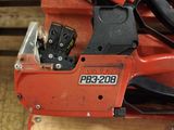 a chainsaw with a chain attached to it on a piece of wood