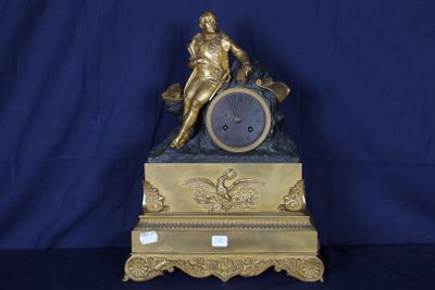 une horloge en or surmontée d'une statue