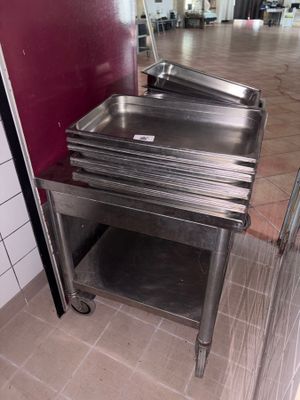 a stainless steel sink in the middle of a tiled floor