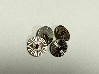 several silver metal buttons are sitting on top of a white surface
