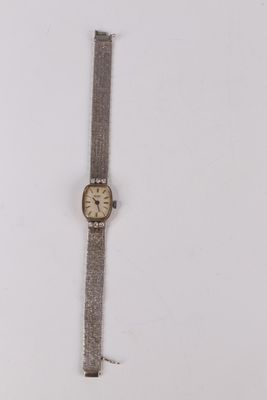 an old wrist watch sitting on top of a white surface