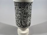 a black and white vase with a city drawing on it