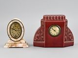 two clocks sitting next to each other on a table