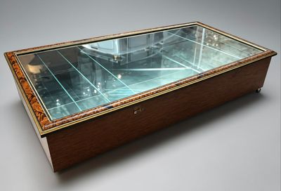 a glass display case with a clock on top of it