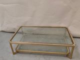 a glass and brass coffee table with a glass top