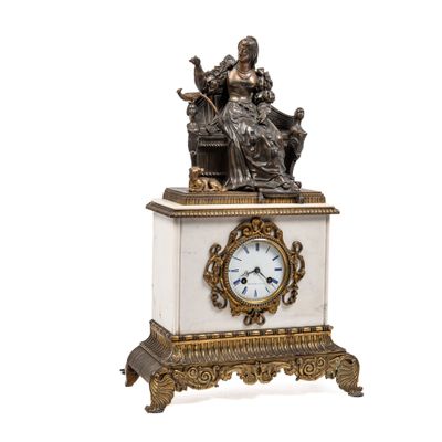 une petite horloge surmontée d'une statue
