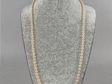 a necklace with pearls and gold beads on a mannequin
