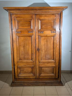 a wooden armoire in the middle of a tiled floor