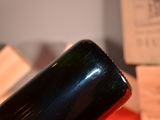 a bottle of wine sitting on a table next to a stack of boxes