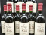 six bouteilles de vin rouge sont alignées sur une table