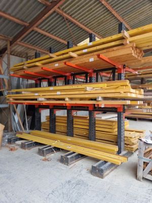 a large amount of wood in a warehouse with pallets