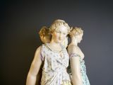 une statue représentant une femme portant un enfant sur le dos