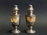 deux vases en argent posés l'un à côté de l'autre sur une table
