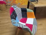 une chaise en patchwork colorée devant un mur coloré