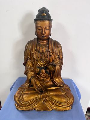statue de Bouddha assis sur une table bleue recouverte d'un tissu bleu