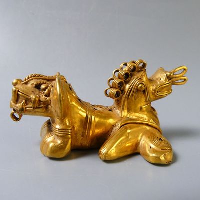 gold figurine of a horse with a rider on it ' s back
