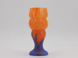 an orange and blue vase sitting on a white surface