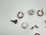 a lot of earrings and a pocket watch sitting on a table