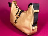 a close up of a gold purse on a pink background