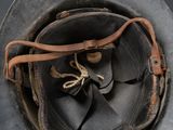 a close up of a helmet with a leather strap on it