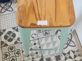 a wooden stool sitting on a tiled floor in a kitchen
