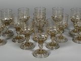 huit verres à vin sont alignés sur une surface blanche