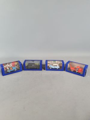a group of six toy cars in blue boxes on a white surface