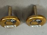 two brass knobs with the words luck and luck written on them