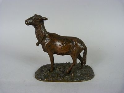 statue en bronze représentant une chèvre posée sur un rocher, sur fond blanc