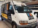 un homme debout à côté d'une camionnette dans un garage