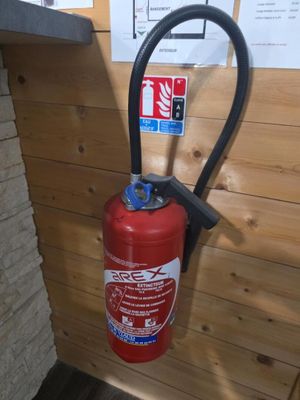 un extincteur fixé au mur d'une pièce
