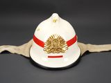 a white fireman ' s hat with a red ribbon on it