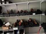 il y a beaucoup de chaussures sur les étagères dans la pièce