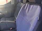 the back of a van with a seat covered in blue cloth