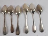 six spoons are lined up in a row on a white surface