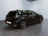 the black car is parked in a large room in a building