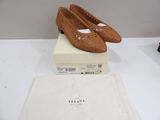 pair of tan leather shoes sitting on top of a box on a white table