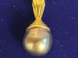 yellow gold pearl pendant on a blue background