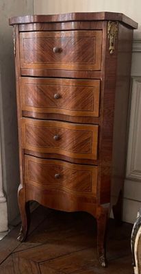 a small chest of drawers in the corner of a room