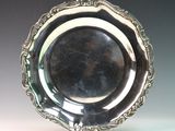 an antique silver plate with a decorative design on the rim