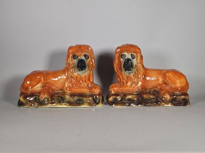 une paire de figurines de chiens en céramique posées sur un fond blanc