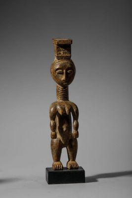 une statue en bois représentant une femme avec un panier sur la tête