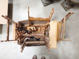 une personne debout à côté d'une pile de chaises en bois