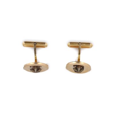 une paire de boutons de manchette plaqués or sur fond blanc