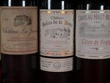 several bottles of wine are lined up in a row on a shelf