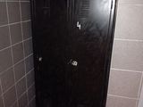 a black locker in the corner of a tiled bathroom