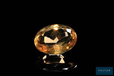 a close up of a yellow diamond on a black surface