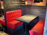 une cabine rouge avec une table noire et des chaises rouges
