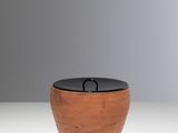 a close up of a wooden bowl with a black lid