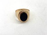gros plan d'une bague en or avec une pierre noire